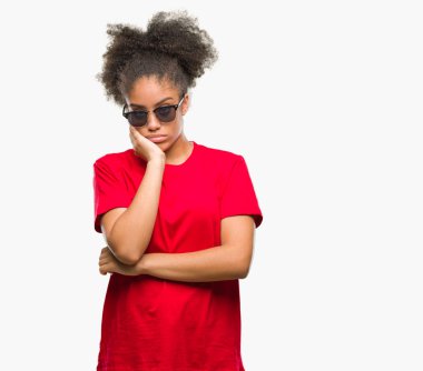 Genç afro Amerikalı kadın seyir yorgun ve bıkkın ile depresyon sorun Çapraz kollar ile izole arka plan düşünme üzerinde güneş gözlüğü takıyor.