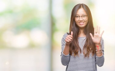 Genç Asyalı kadın gösterilen ve parmakları ile işaret izole arka plan üzerinde 6 numara 