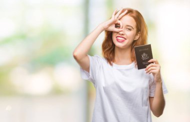 Amerika Birleşik Devletleri pasaport ile mutlu yüz el parmaklarının arasından seyir göz üzerinde ok işaretiyle yapıyor gülümseyen izole arka plan üzerinde tutan genç güzel kadın