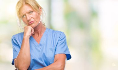 Orta yaş sarışın kadın doktor hemşire üniforması düşünme izole arka plan bakmaktan yorgun ve sıkılmış çapraz silah depresyon sorunları ile.