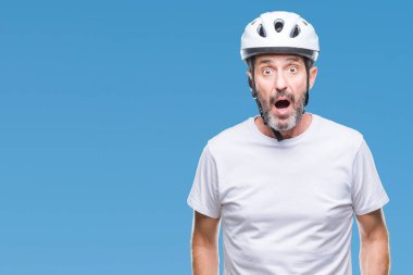 Bisiklet Emanet helment giyen orta yaş üst düzey ağarmış bisikletçi adam arka plan korkuyor ve şok sürpriz ifade, korku ve heyecan yüz ile izole.