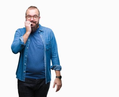 Genç beyaz hipster adam stresli ve gergin elle çivi ısırma ağzına bakarak izole arka plan üzerinde gözlük takıyorum. Anksiyete sorunu.