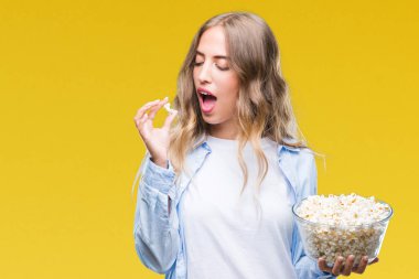 Acımak yüz ciddi düşünüyorum üstünde kendine güvenen bir ifade ile izole arka plan üzerinde patlamış mısır yemek güzel sarışın genç kadın