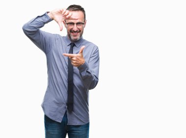 Orta yaş ağarmış üst düzey iş adamı elle yapma çerçeve ve parmakları ile mutlu yüz gülümseyen izole arka plan üzerinde gözlük takıyorum. Yaratıcılık ve Fotoğrafçılık kavramı.