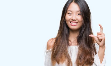 Genç Asyalı kadın boyutu işareti yapıyor izole arka plan üzerinde 