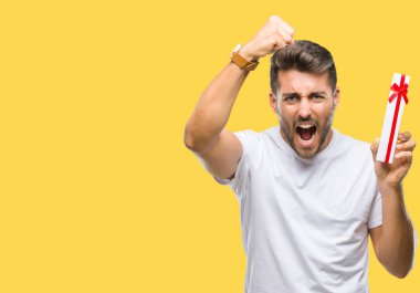 Sevgililer hediye izole üzerinden veren aşık genç yakışıklı adam arka plan ile öfke, çılgın ve yükseltilmiş eliyle diye bağıran rahatsız ve hayal kırıklığına uğramış öfke kavramı bağırarak