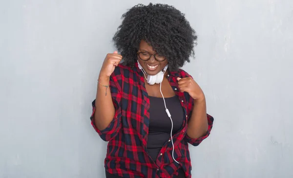 Unga Afroamerikanska Kvinnan Över Grå Grunge Vägg Bär Hörlurar Mycket — Stockfoto
