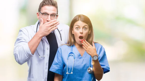 年轻夫妇的医生和外科医生在孤立的背景震惊覆盖嘴与手的错误 秘密概念 — 图库照片