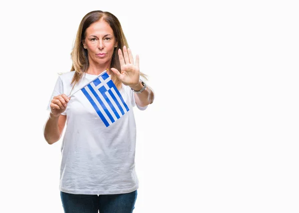 孤立した背景に防衛ジェスチャー 深刻な自信を持って式に一時停止の標識を行うオープン手でギリシャの旗を保持している中年ヒスパニック系女性 — ストック写真