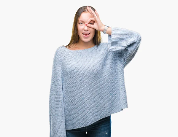 Gülümseyerek el parmakları ile mutlu yüz üzerinden seyir göz ile ok jest yapıyor izole arka plan üzerinde kış kazak giyen genç güzel beyaz kadın.