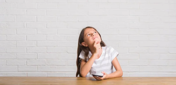 Niño Hispano Joven Sentado Mesa Usando Teléfono Inteligente Cara Seria — Foto de Stock