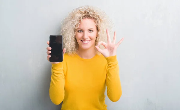 Mujer Rubia Joven Sobre Fondo Gris Grunge Mostrando Pantalla Blanco —  Fotos de Stock