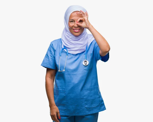 看護師の中高年シニア アラブ笑顔 幸せそうな顔で指を通して見る目の手で のジェスチャーを行う分離の背景にヒジャーブを着ている女性 — ストック写真