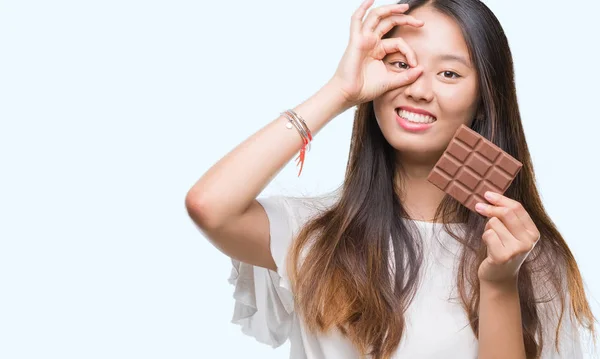 Young Asian Woman Eating Chocolate Bar Isolated Background Happy Face — Stock Photo, Image