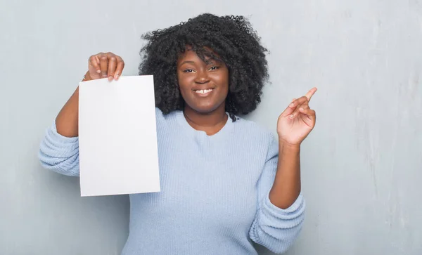 Unga Afroamerikanska Kvinnan Över Grå Grunge Väggen Håller Tomt Papper — Stockfoto