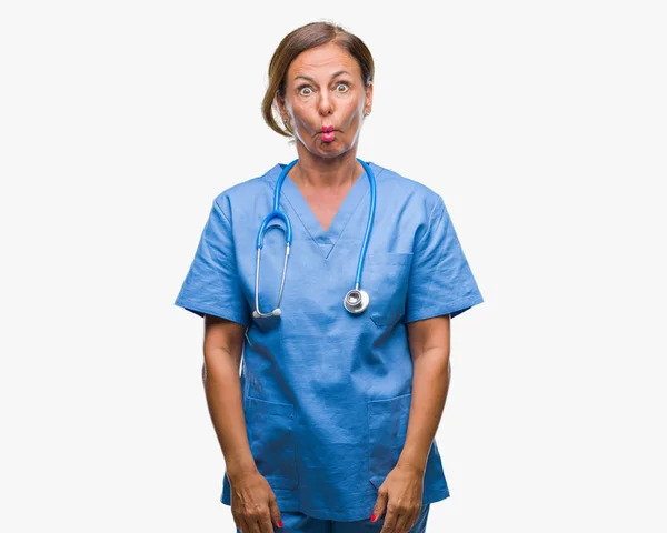 中年资深护士医生妇女在孤立的背景下做鱼脸与嘴唇 疯狂和滑稽的手势 滑稽的表达 — 图库照片