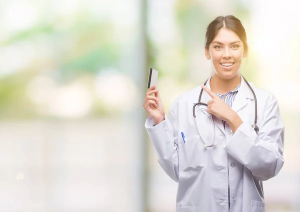 Joven Doctora Hispana Sosteniendo Tarjeta Crédito Muy Feliz Apuntando Con — Foto de Stock