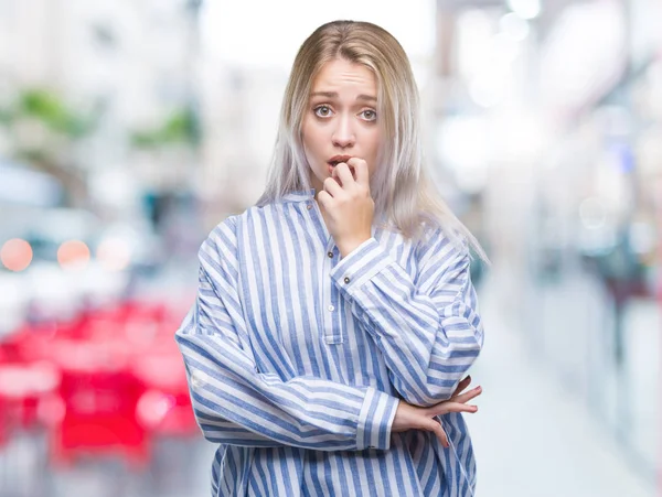 年轻的金发女人在孤立的背景下 看着压力和紧张的嘴咬指甲的手 焦虑问题 — 图库照片