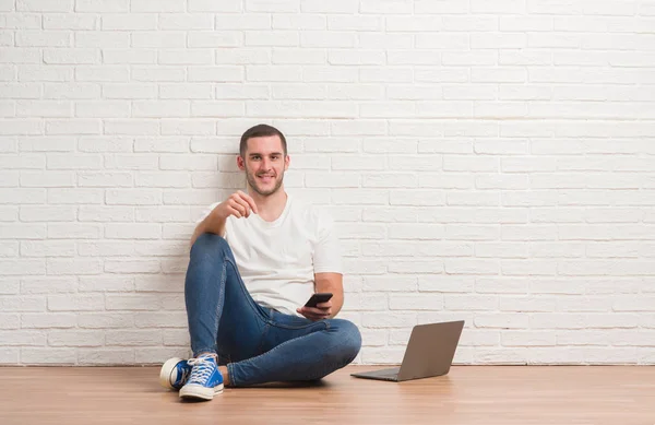 Joven Hombre Caucásico Sentado Sobre Pared Ladrillo Blanco Usando Computadora — Foto de Stock