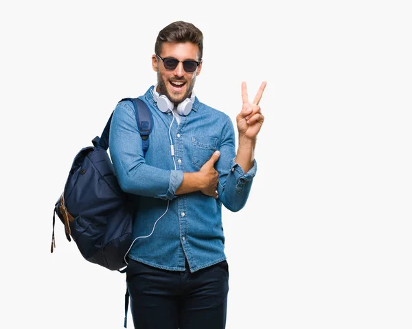 Junger Gutaussehender Touristenmann Mit Kopfhörern Und Rucksack Vor Isoliertem Hintergrund — Stockfoto