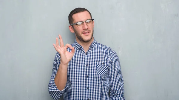 Молодий Кавказький Бізнесмен Над Сірою Гранжевою Стіною Робить Знак Пальцями — стокове фото