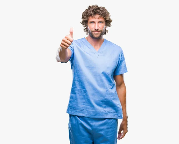 英俊的西班牙医生的人在孤立的背景做愉快的拇指手势与手 批准表达式看着相机显示成功 — 图库照片