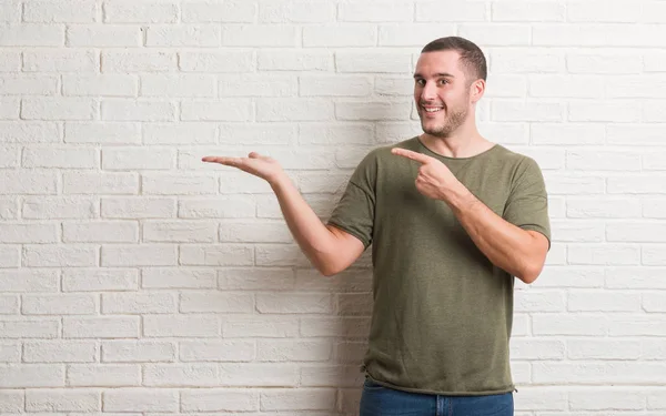 Joven Hombre Caucásico Pie Sobre Pared Ladrillo Blanco Sorprendido Sonriendo — Foto de Stock