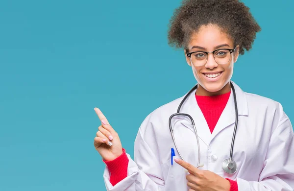 年轻的黑人美国医生妇女在孤立的背景微笑 看着相机指着两个手和手指到一边 — 图库照片
