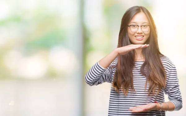 眼鏡をかけて大きな 大きなサイズの兆しの手でジェスチャー分離の背景の上若いアジア女性 — ストック写真