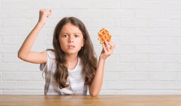 ワッフルとイライラと不満の叫び怒り 狂気と上げられた手で叫んで怒りの概念を食べるテーブルの上に座って若いヒスパニックの子供 — ストック写真