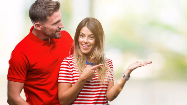 Young Couple Love Isolated Background Amazed Smiling Camera While Presenting — Stock Photo, Image