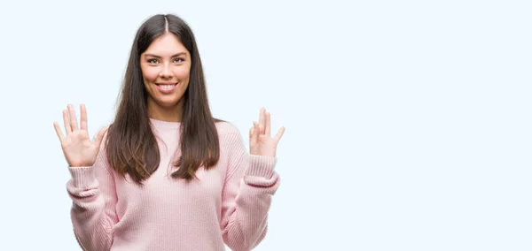 身に着けているセーターを示すと指で上向き若い美しいヒスパニック女性数 自信を持って 幸せな笑みを浮かべて — ストック写真