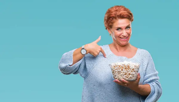 Atrativo Mulher Ruiva Caucasiana Sênior Comendo Pipocas Sobre Fundo Isolado — Fotografia de Stock