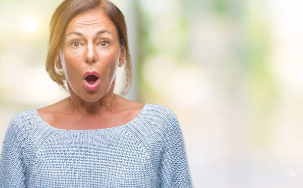 Orta yaş İspanyol kadın kıdemli giyen kış kazak korkuyor ve şok sürpriz ifade ile izole arka plan üzerinde korku ve yüz heyecanlı.