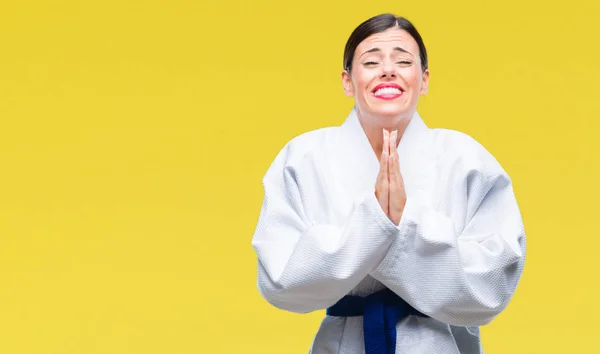 年轻美丽的女人穿着空手道和服制服在孤立的背景乞讨和祈祷与手在一起与希望表情在脸上非常情绪化和担心 请求宽恕 宗教概念 — 图库照片