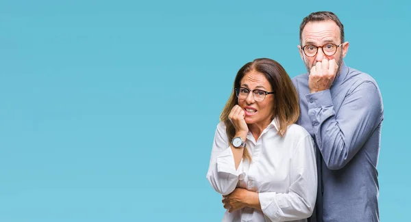 中年西班牙夫妇在爱戴眼镜在孤立的背景看起来紧张和紧张的手在嘴咬指甲 焦虑问题 — 图库照片