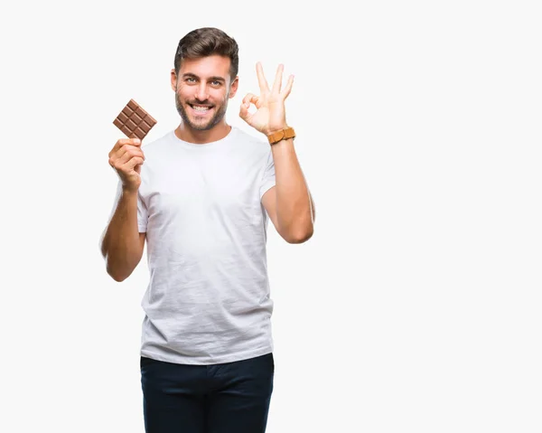 Young Handsome Man Eating Chocolate Bar Isolated Background Doing Sign — Stock Photo, Image
