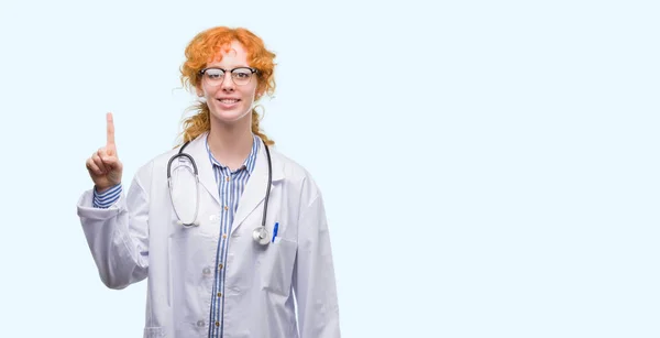 Jovem Ruiva Vestindo Uniforme Médico Mostrando Apontando Para Cima Com — Fotografia de Stock