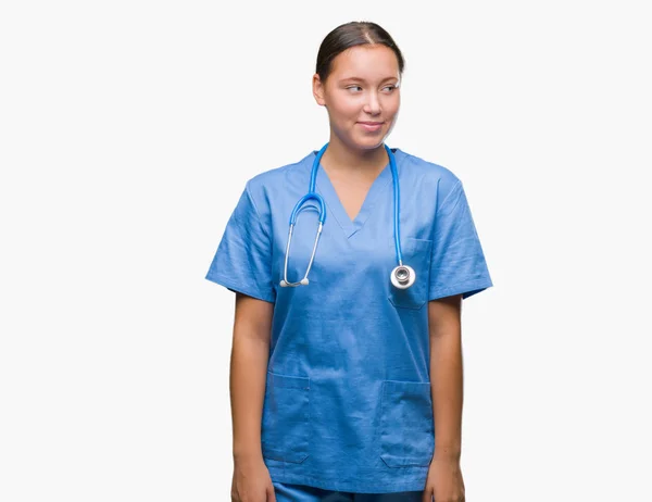 笑って見ている側と見つめて離れて思考孤立の背景に医療制服を着て若い白人医師女性 — ストック写真