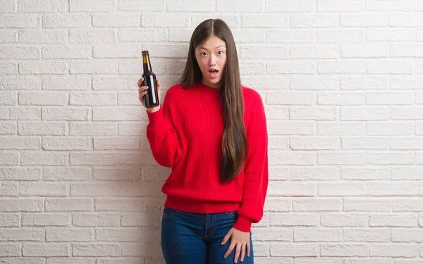 Joven Mujer China Sobre Pared Ladrillo Bebiendo Cerveza Asustada Shock — Foto de Stock