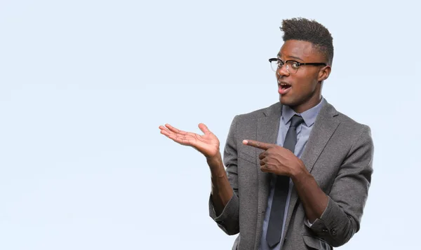 Молодой Афроамериканец Бизнесмен Изолированном Фоне Удивился Улыбнулся Камеру Показывая Рукой — стоковое фото