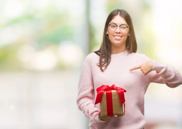 Young Hispanic Woman Holding Gift Surprise Face Pointing Finger Himself — Stock Photo, Image