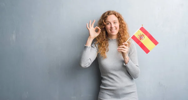 Joven Pelirroja Sobre Pared Grunge Gris Sosteniendo Bandera España Haciendo —  Fotos de Stock