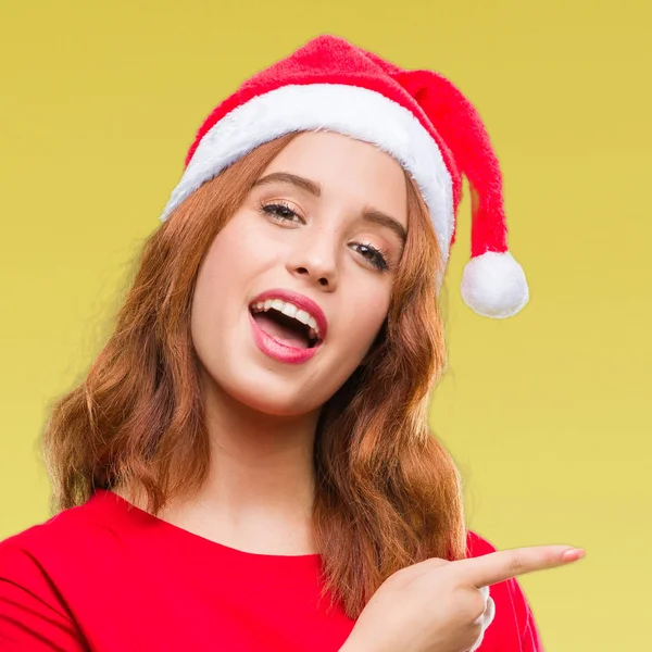 年轻美丽的女人在孤立的背景下戴着圣诞帽惊讶和微笑的相机 而提出用手和手指指着 — 图库照片