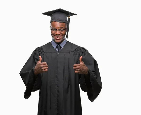 年轻毕业的非洲裔美国人在孤立的背景成功标志做积极的手势与手 竖起大拇指微笑和快乐 用欢快的表情看着相机 胜利者的手势 — 图库照片