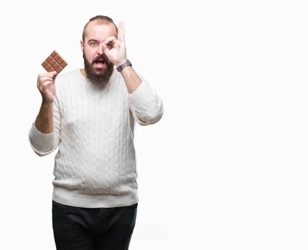 Joven Hipster Hombre Comiendo Barra Chocolate Sobre Fondo Aislado Con — Foto de Stock