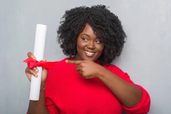 Unga Afroamerikanska Kvinnan Över Grå Grunge Väggen Håller Diplom Mycket — Stockfoto