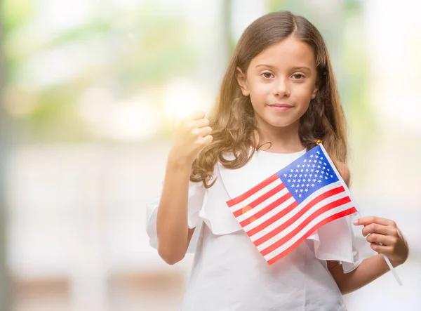 Brunette hispanic girl holding flag of United States of America happy with big smile doing ok sign, thumb up with fingers, excellent sign