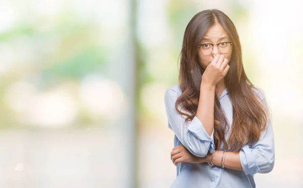 年轻的亚洲商界女性戴着眼镜 在与世隔绝的背景下闻到一些臭味和恶心 难以忍受的气味 用手指在鼻子上屏住呼吸 坏气味概念 — 图库照片