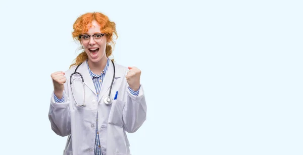 若い赤毛の女性医師制服を祝っている身に着けている驚いて腕を上げると成功のため驚くし 目を開きます 勝者の概念 — ストック写真